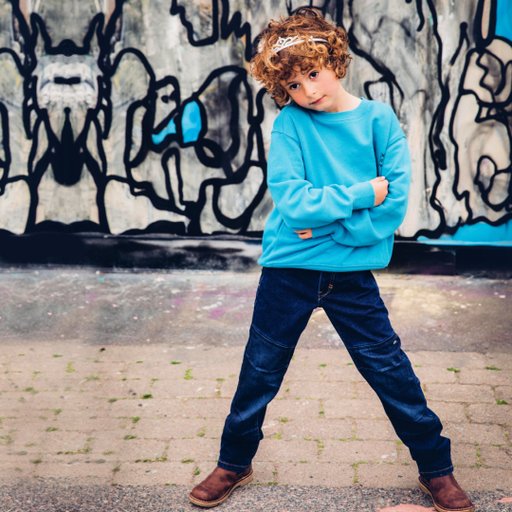 Ett barn som har på sig Ossoami slitstarka jeans från Gneis