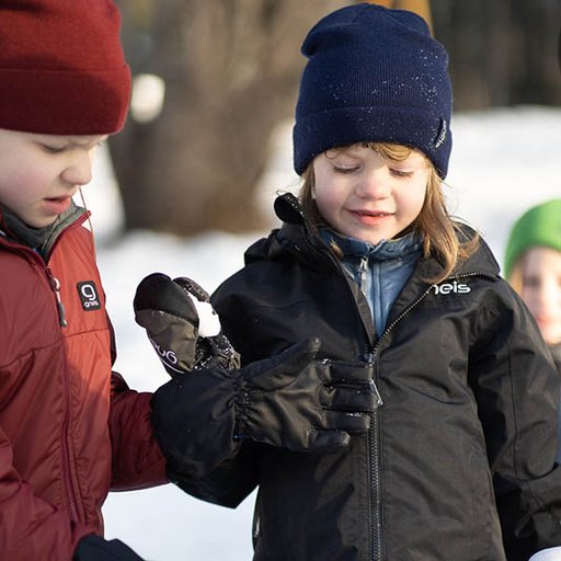 Två barn som leker i snön