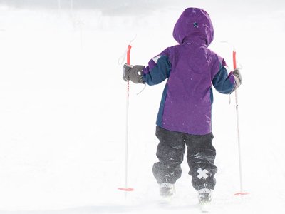 Gneis Speed vinterjacka. Barn åker längdskidor i snöyra.
