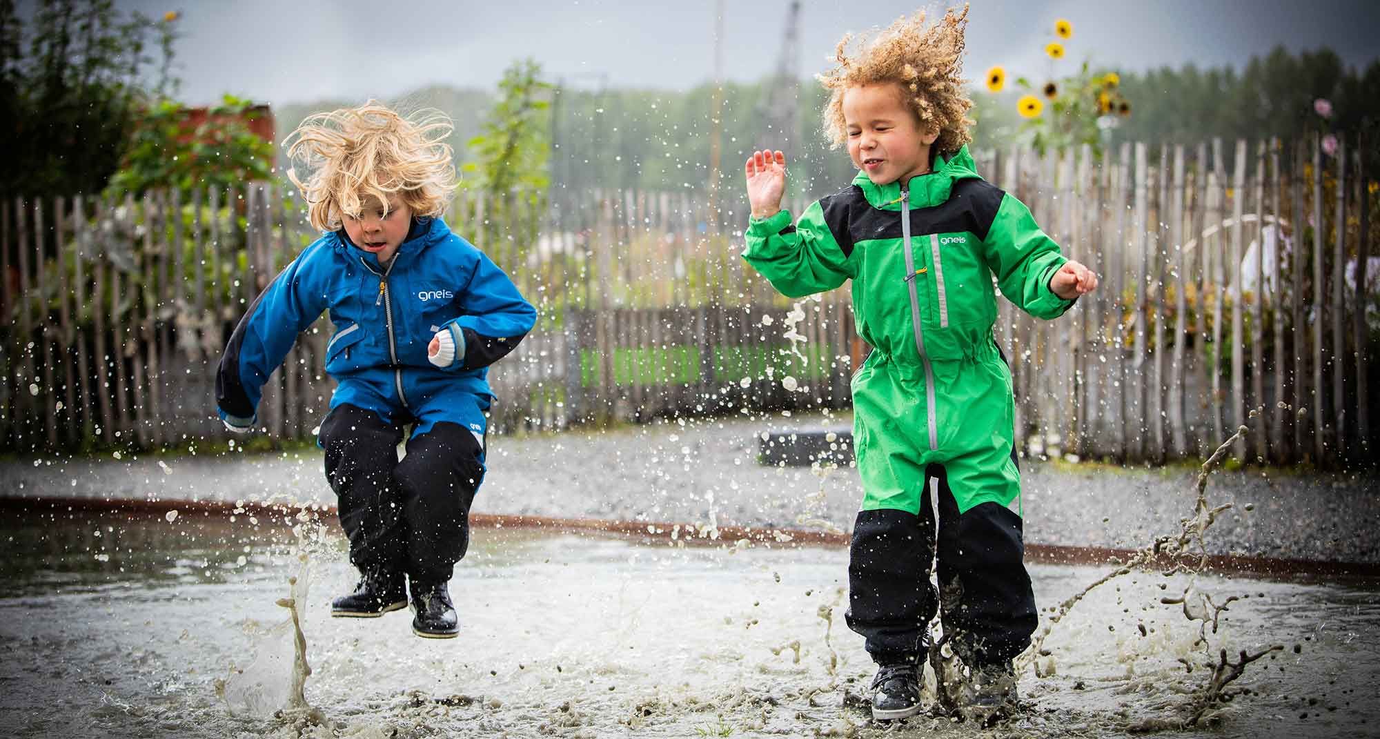 Barn som hoppar i pölar med Gneis skaloveraller