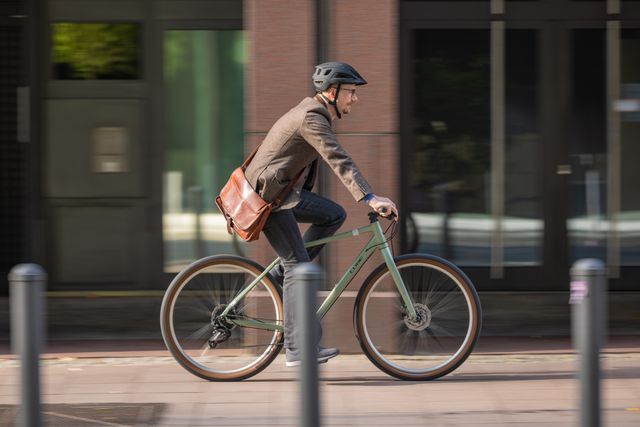 Mies pyöräilemässä Cube-pyörällä kaupungissa.