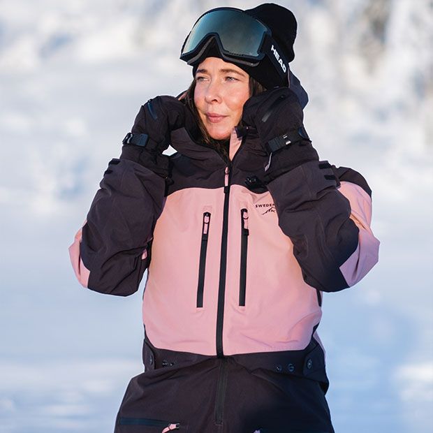 Eine Frau trägt eine rosa-schwarze Skijacke aus der Kollektion Freeride.